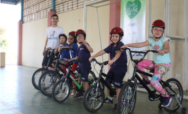 Crianças aprendem a andar de bicicleta durante as aulas de educação física